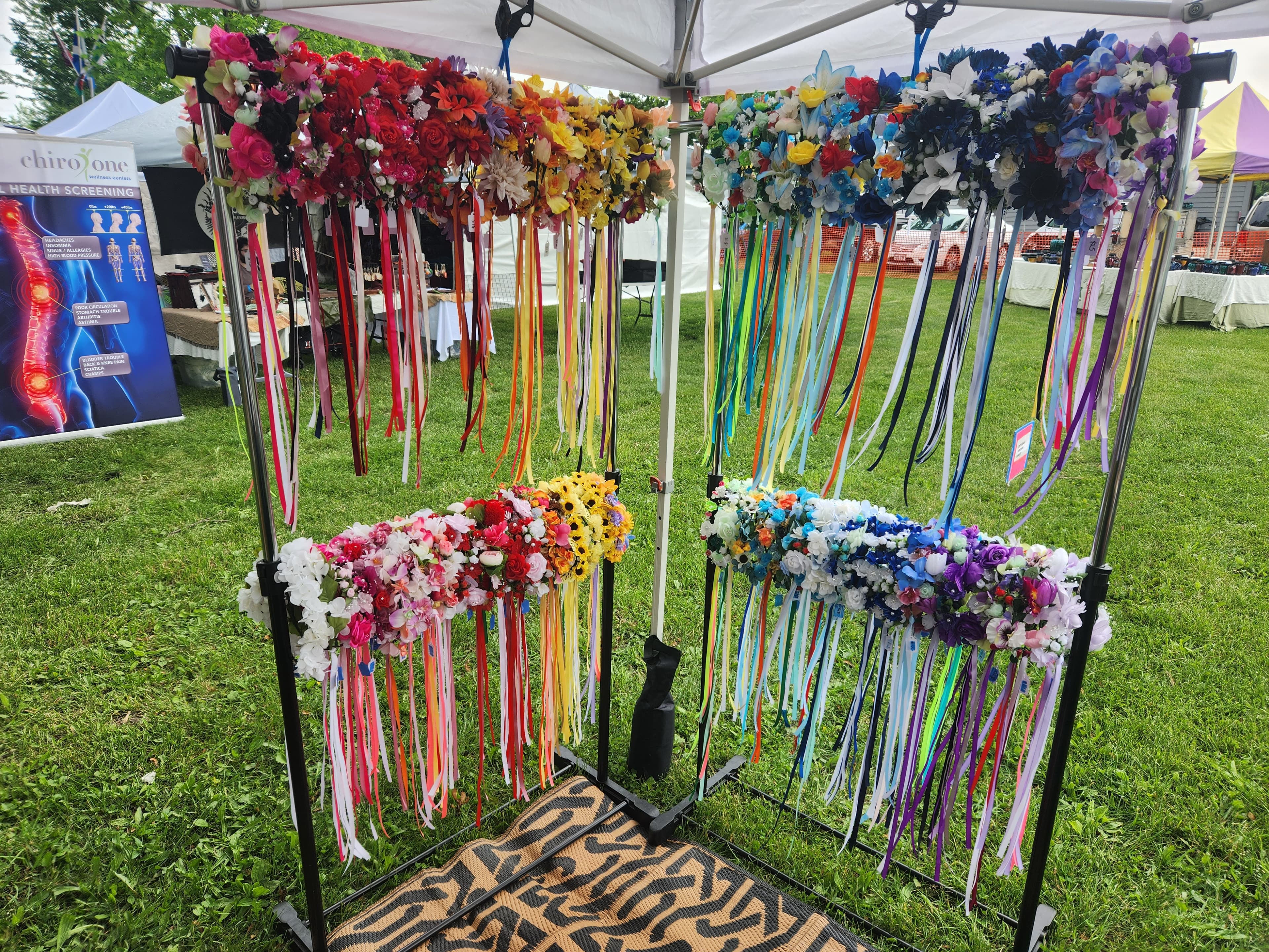 Our flower crowns on display at an outdoor event. If you see us at an event, feel free to try one on! Check our shop page to customize your own flower crown, hand crafted by us!